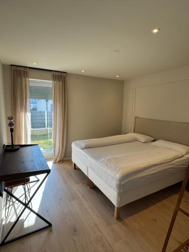 a bedroom with a bed and a table and a window at Römer Apartment und Zimmer in Türkheim