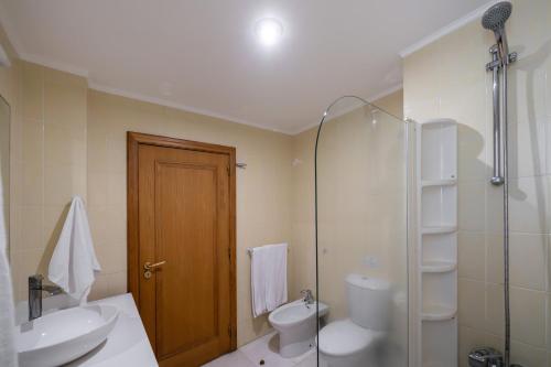 Un baño con inodoro, lavabo y ducha. en Arcadas III by An Island Apart, en Funchal