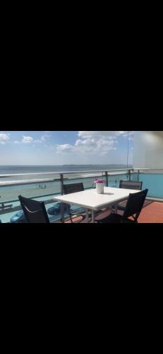 une table et des chaises sur un balcon donnant sur l'océan dans l'établissement Spacious bright nest with balcony facing the sea, à Pornichet