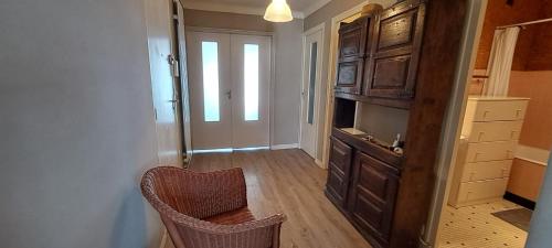 Cette chambre dispose d'une télévision, d'une chaise et d'une armoire. dans l'établissement Spacious bright nest with balcony facing the sea, à Pornichet