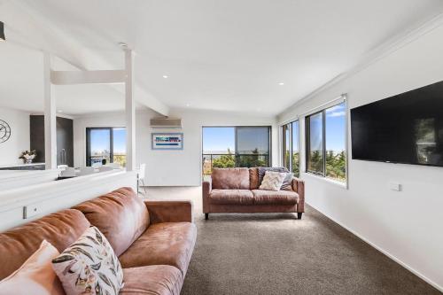 a living room with a couch and a television at The Beach House - Views & Games Room in Mount Martha