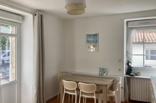 une salle à manger avec une table et des chaises et une fenêtre dans l'établissement Apartment with parking in city center, à Pornichet
