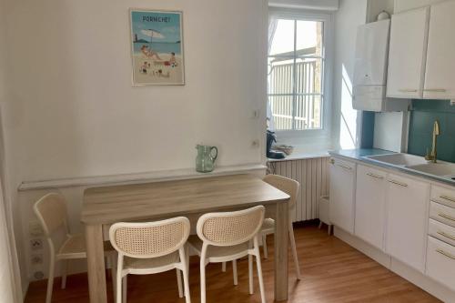 une cuisine avec une table et des chaises en bois dans l'établissement Apartment with parking in city center, à Pornichet