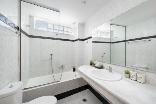 a bathroom with a sink and a tub and a toilet at Bellevue Suites in Agios Nikolaos