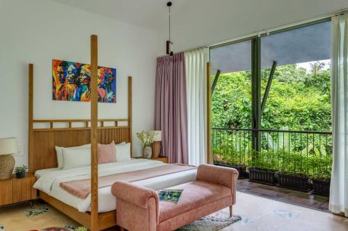 ein Schlafzimmer mit einem Bett und einem großen Fenster in der Unterkunft Casa Maxima - Luxury 4bhk villa with pool in Goa