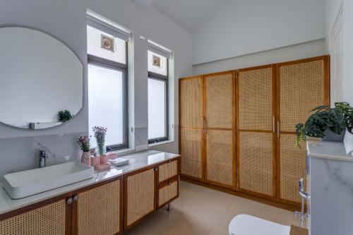 ein Badezimmer mit Waschbecken und Spiegel in der Unterkunft Casa Maxima - Luxury 4bhk villa with pool in Goa