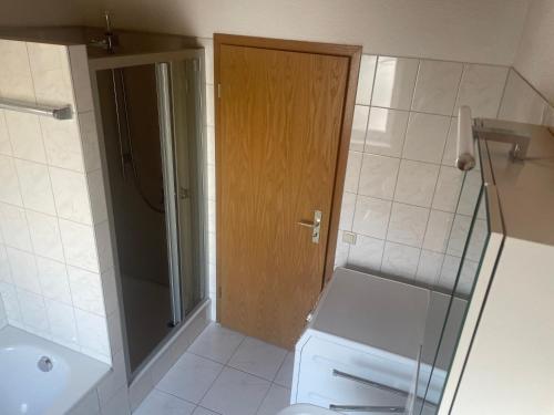 a bathroom with a toilet and a wooden door at Ferienwohnung Loder Dachgeschoss in Blumberg