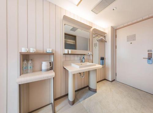 a bathroom with a sink and a mirror at Hanting Hotel Beijing Shangdi Zhongguancun Software Park in Beijing