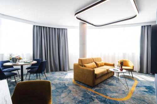a living room with a couch and chairs and tables at Focus Hotel Premium Wrocław in Wrocław