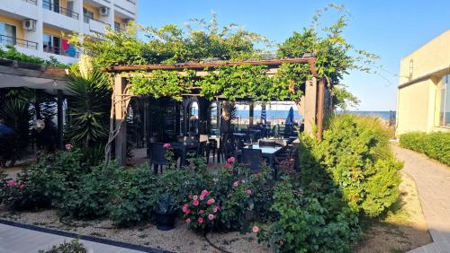 a garden with a pergola with flowers and plants at Hotel Cometa in Jupiter