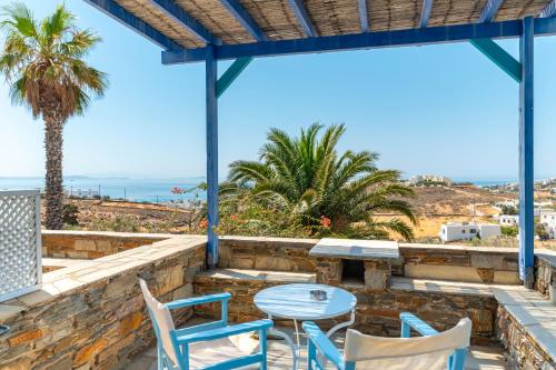 a patio with a table and chairs and the ocean at La Casa Tinos 22 in Agios Ioannis Tinos