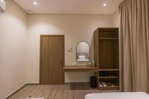 a bedroom with a door and a mirror at Ivory House Resort - Ophiolite in Hatta