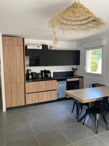 une cuisine avec une table en bois et une salle à manger dans l'établissement Clairière du Cap Brun, à Toulon