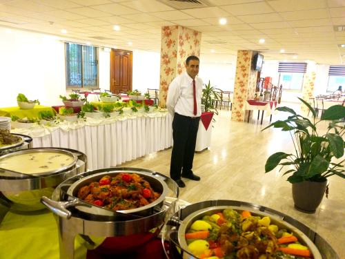 a man standing in a room with a bunch of food at City Inn Palace Hotel in Ramallah