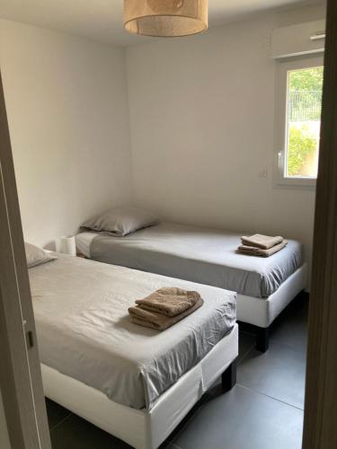 deux lits dans une chambre avec des serviettes dessus dans l'établissement Clairière du Cap Brun, à Toulon