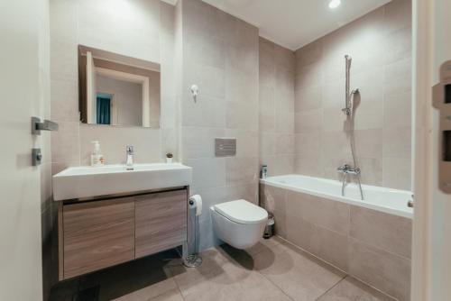 a bathroom with a sink and a toilet and a tub at BW Cityline Residences in Belgrade
