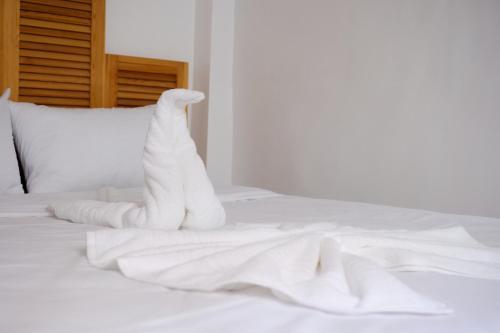 a stuffed animal is sitting on a white bed at Surfer's Heimat Hostel in Tamraght Ouzdar