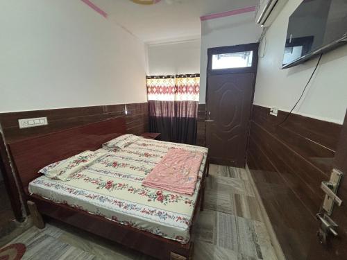 a small bedroom with a bed and a door at Hotel Lala Ji in Nīthrāna