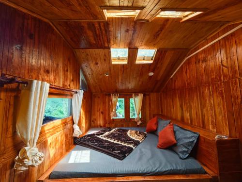 Wilderness Cottages and camps kasol في كاسول: سرير في وسط غرفة خشبية