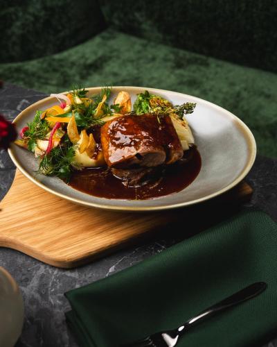 a plate of food with meat and vegetables on a table at Focus Hotel Premium Wrocław in Wrocław