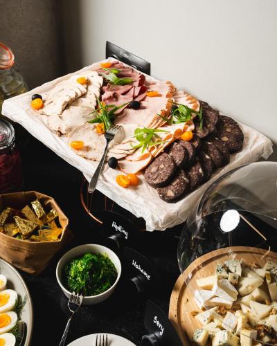 a table topped with a buffet of food with meat and vegetables at Focus Hotel Premium Wrocław in Wrocław
