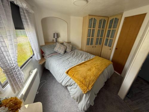 a small bedroom with a bed and a window at Caravan in Banff