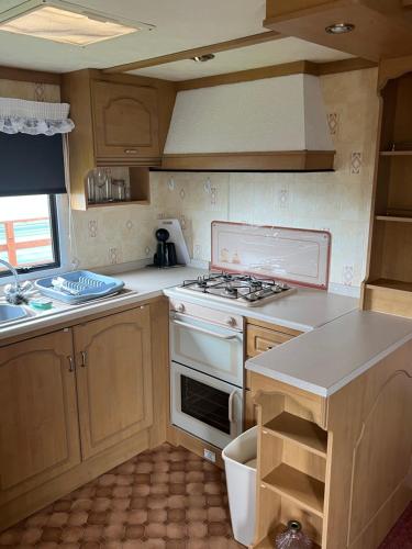 a kitchen with a stove and a sink at Caravan in Banff