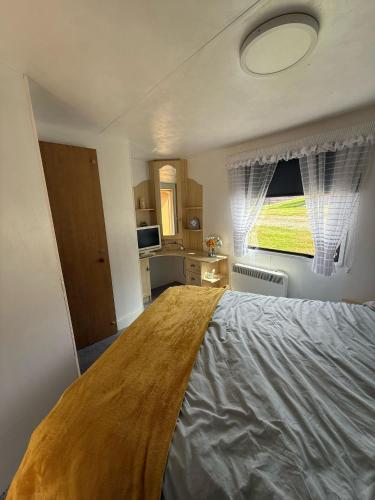 a bedroom with a large bed and a window at Caravan in Banff