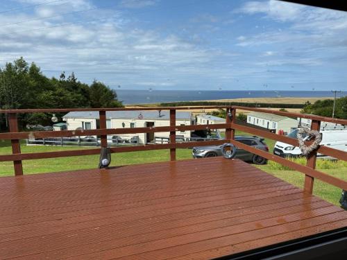a wooden deck with a view of the beach at Caravan in Banff
