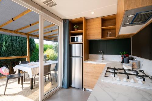 - une cuisine et une salle à manger avec une table et une cuisinière dans l'établissement Domaine Les Jardins de Kergal, à Guidel-Plage