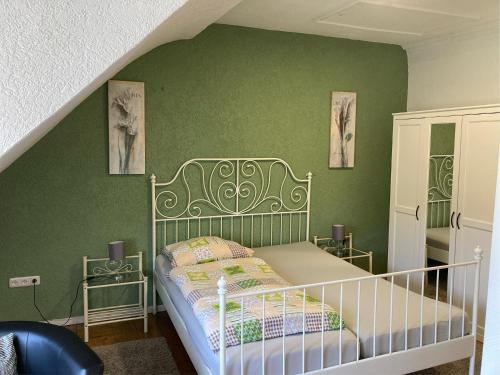 a bedroom with a bed in a green wall at Gästehaus Flair in Mettlach
