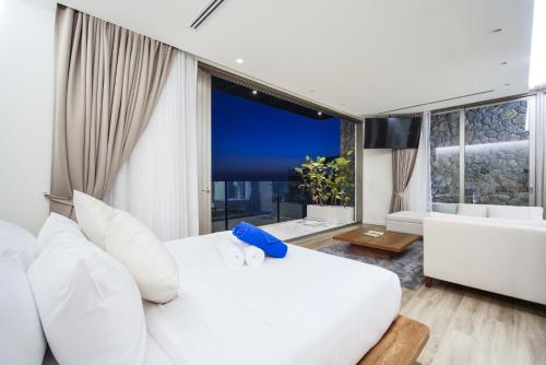 a bedroom with a white bed and a large window at Sea Theatre Kata by ROI in Ban Nong Chaeng
