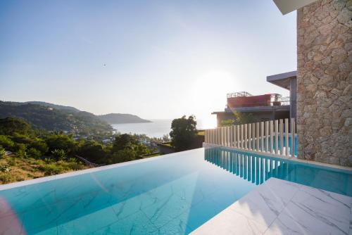 a swimming pool on the side of a house at Sea Theatre Kata by ROI in Ban Nong Chaeng