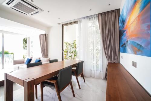 a dining room with a wooden table and chairs at Sea Theatre Kata by ROI in Ban Nong Chaeng