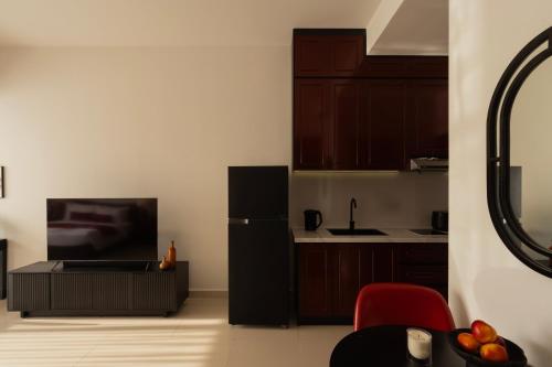 a kitchen with a black refrigerator and a sink at DingD0ng Suites - The Sun Avenue - Free Pool & Gym in Ho Chi Minh City