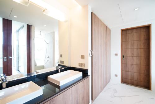 a bathroom with two sinks and a large mirror at Sea Theatre Kata by ROI in Ban Nong Chaeng