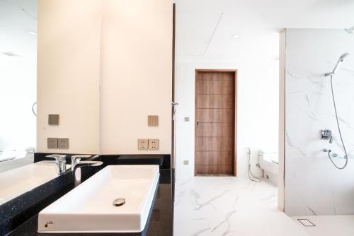 a white bathroom with a sink and a toilet at Sea Theatre Kata by ROI in Ban Nong Chaeng