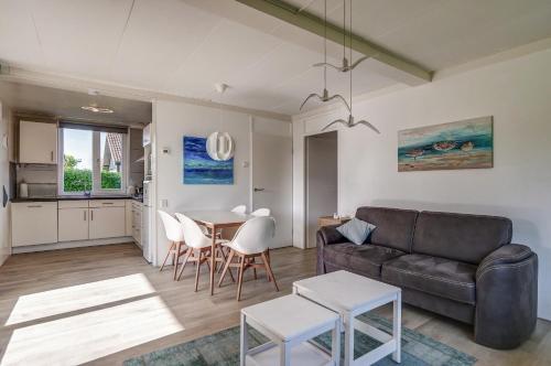 ein Wohnzimmer mit Sofa und Tisch in der Unterkunft Vakantiehuis De Strandloper - Julianadorp aan Zee in Julianadorp