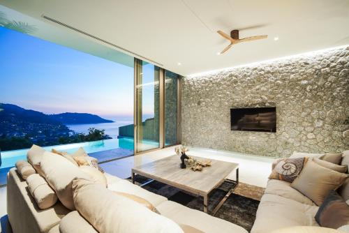 a living room with a couch and a table at Sea Theatre Kata by ROI in Ban Nong Chaeng