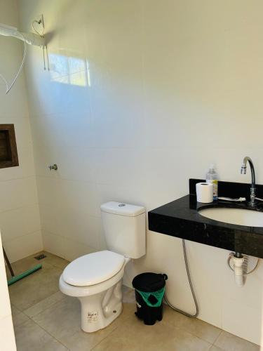 a bathroom with a white toilet and a sink at Recanto Dubom, a 10 minutos do autódromo Goiânia in Bela Vista de Goiás