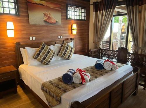 a bedroom with a bed with hats and towels on it at Nilaveli Beach Resort - Level 1 Certified in Nilaveli