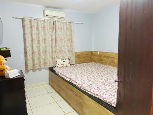 Una cama pequeña en una habitación con ventana. en Recanto Dubom, a 10 minutos do autódromo Goiânia, en Bela Vista de Goiás
