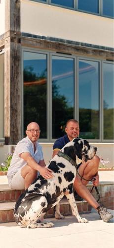 two men and a dog sitting on a step at Kingsley House in Haslemere