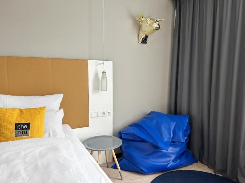 a bedroom with a bed with a blue pillow and a table at Holiday Inn - the niu, Dairy Haarlem in Haarlem