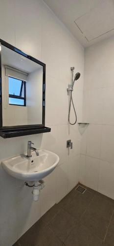 a white bathroom with a sink and a mirror at PD Dwharf The Bay Oceanview Suite in Port Dickson