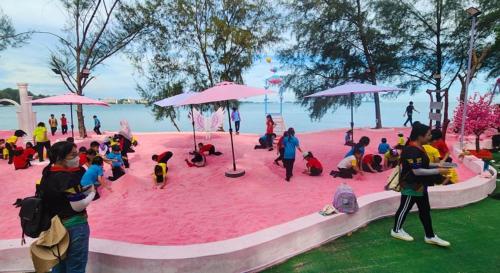 a group of people sitting in a pink sand pit at PD Dwharf The Bay Oceanview Suite in Port Dickson