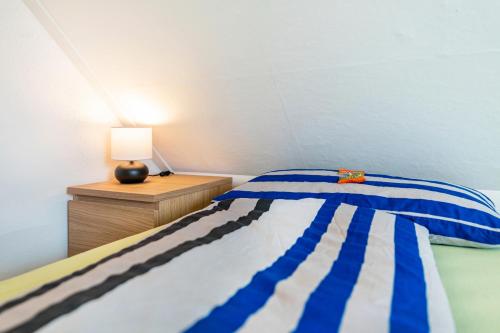a bedroom with a blue and white bed and a lamp at Haus Kasberger in Ascheberg