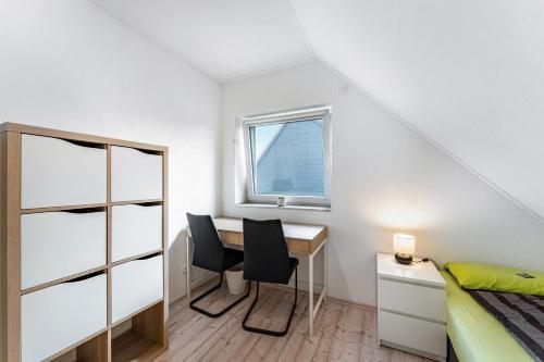 a bedroom with a desk and a bed and a window at Haus Kasberger in Ascheberg
