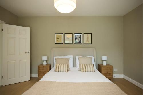 a bedroom with a bed with two pillows and two lamps at The Lindens Garden Retreat - Spacious single-level 4-bed with garden near Maidenhead & River Thames in Maidenhead