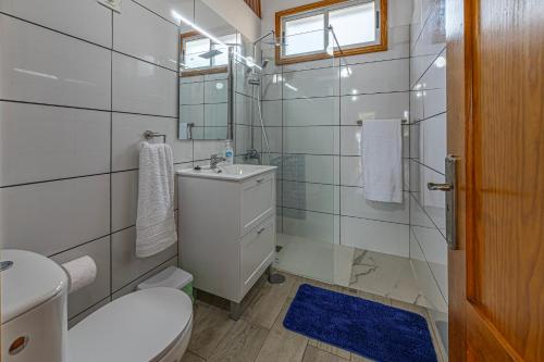 Un baño con un inodoro, un lavabo y un espejo. en Casita Pedro El Remo, en Los Llanos de Aridane